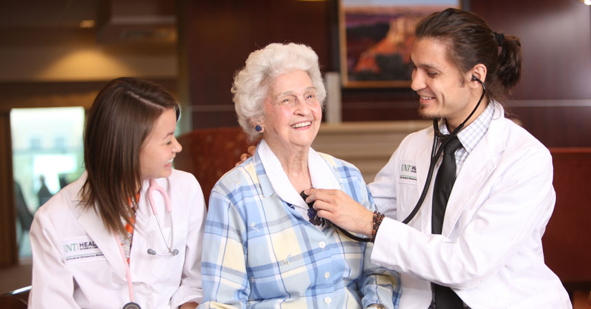 Student and resident examine older adult