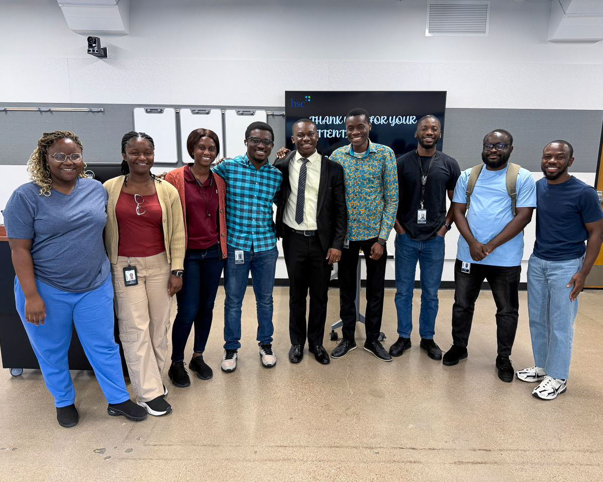 Group of student standing together at the front of a classroom.