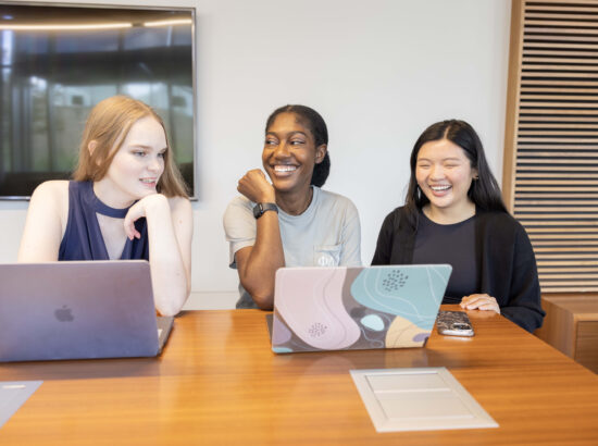 UNT Health students sitting at a table with their laptops