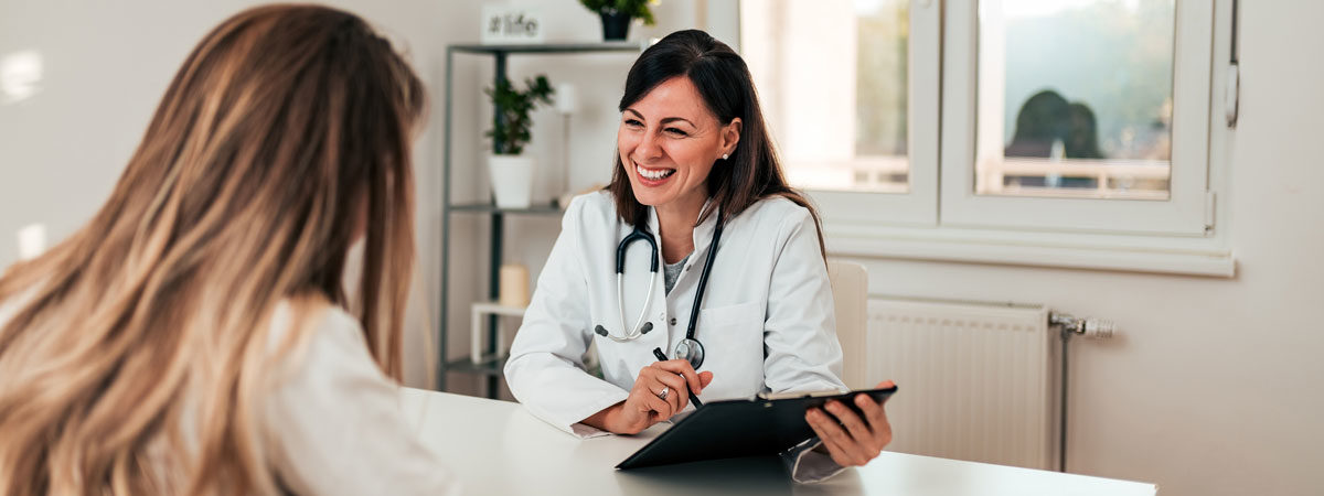 A doctor smiling while speaking with a patient